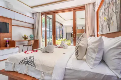a bedroom with a large bed with white sheets and pillows at Villa Yudhistira by JB Villas in Seminyak