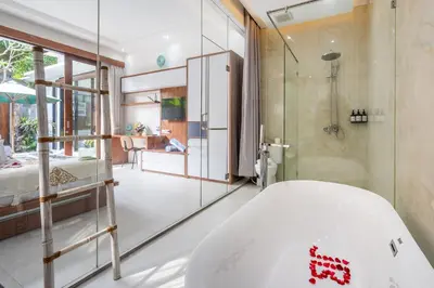 a bathroom with a bath tub and a bedroom at Villa Yudhistira by JB Villas in Seminyak