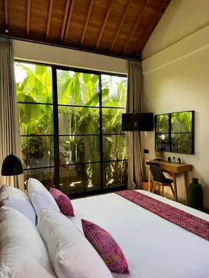 a bedroom with a large bed with a large window at Villa Nelaya - Modern 3BR Retreat Private Pool Walk to the Beach in Seminyak