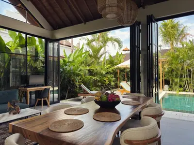 a dining room with a table and chairs and a pool at Villa Nelaya - Modern 3BR Retreat Private Pool Walk to the Beach in Seminyak