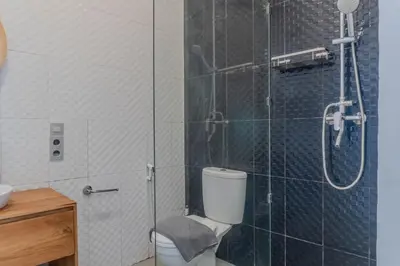 a bathroom with a toilet and a glass shower at NEW! Queen Villa - 2BR Villa in Seminyak in Seminyak