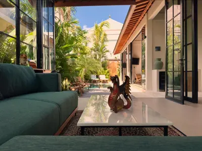 a living room with a couch and a glass table at Villa Allany - Modern 2BR Tropical Hideaway Private Pool in Seminyak