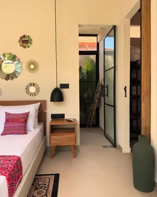 a bedroom with a bed and a table and a mirror at Villa Allany - Modern 2BR Tropical Hideaway Private Pool in Seminyak