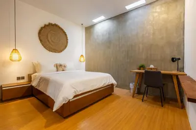 a bedroom with a bed and a desk with a chair at SNUG Kuta in Kuta