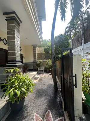 a gate to a house with plants and a palm tree at OSA Guest House 3 in Seminyak