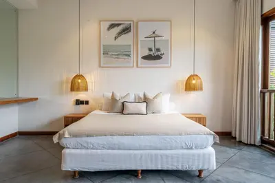 a bedroom with a large bed and two pendant lights at Villa Bettini Stylish 3BR with Pool Near Bintang in Seminyak