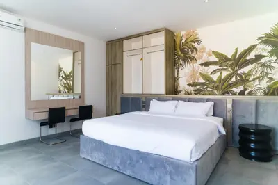a bedroom with a large bed and a desk at New 3 Bedroom Villa with rooftop central Seminyak in Seminyak
