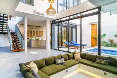 a living room with a green couch and a pool at New 3 Bedroom Villa with rooftop central Seminyak in Seminyak