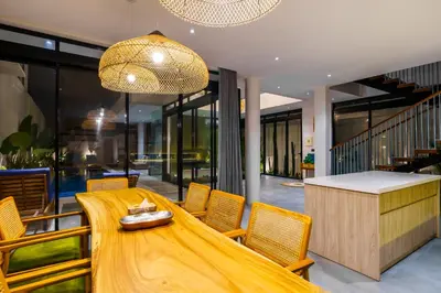 a dining room with a wooden table and chairs at New 3 Bedroom Villa with rooftop central Seminyak in Seminyak