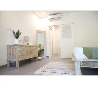 a living room with a couch and a wooden cabinet at New 3BR Orchid Private Pool Villa Seminyak in Seminyak