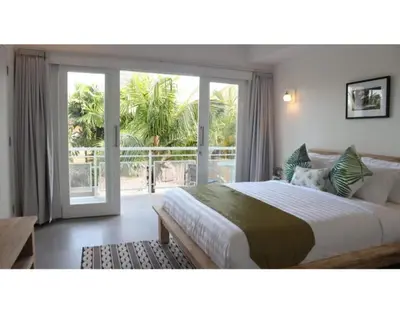 a bedroom with a large bed and a sliding glass door at New 3BR Orchid Private Pool Villa Seminyak in Seminyak