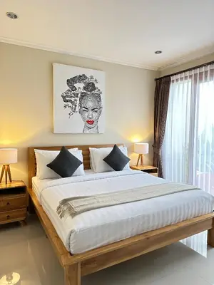 a bedroom with a large bed with two lamps at Villa Karma Damai in Seminyak