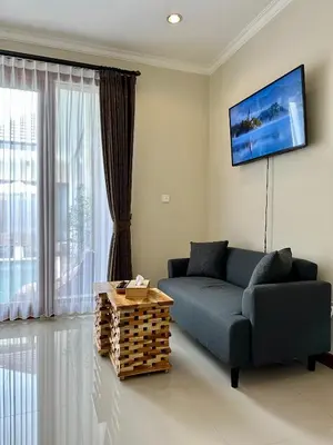 a living room with a couch and a tv at Villa Karma Damai in Seminyak