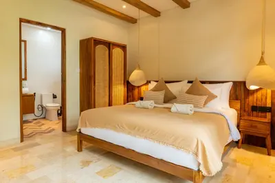 a bedroom with a large bed and a bathroom at Tuluscoliving Villa Kuta 1, 4 Bedroom & 5 Bathroom in Ngurah Rai International Airport