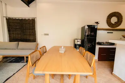a kitchen with a wooden table and chairs at Villa Nagomi in Seminyak