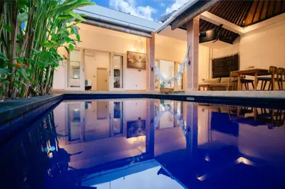 a swimming pool in front of a house at Villa Nagomi in Seminyak