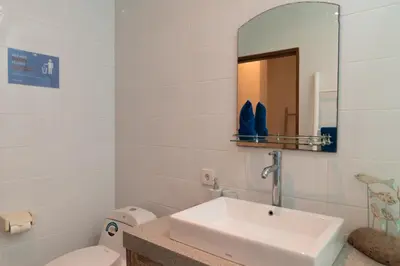 a bathroom with a sink and a toilet and a mirror at Villa Lima Legian in Seminyak
