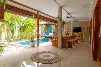 a villa with a swimming pool and a dining room at Villa Lima Legian in Seminyak