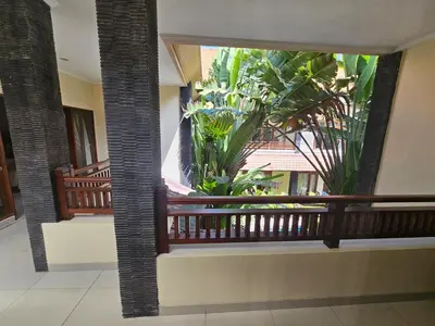 a balcony with a large window with plants in it at Cempaka Apartment Surfaris Inn in Legian