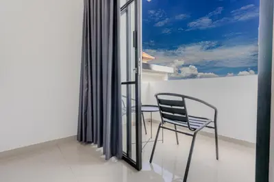 a balcony with a chair and a window at Homely Bali at Kayu Aya in Seminyak