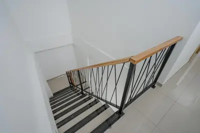 a staircase in a building with a wooden rail at Homely Bali at Kayu Aya in Seminyak