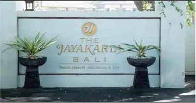 two potted plants sitting in front of a sign at The Palmana Tropical Garden Jayakarta Residence 36 in Seminyak