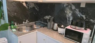 a kitchen counter with a sink and a microwave at The Palmana Tropical Garden Jayakarta Residence 36 in Seminyak