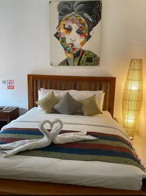 a bedroom with a bed with two swans on it at RBE Hotel Kuta- 5 Min to Airport&Beach by Micky Studio in Ngurah Rai International Airport
