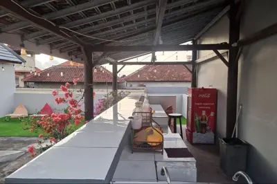 a patio with a wooden pergola and a table at RBE Hotel Kuta- 5 Min to Airport&Beach by Micky Studio in Ngurah Rai International Airport