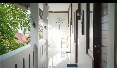 a hallway of a house with a door and a chair at RBE Hotel Kuta- 5 Min to Airport&Beach by Micky Studio in Ngurah Rai International Airport
