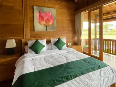 a bedroom with a large bed with a large window at Uma Padi Cabin Umalas Bali in Kerobokan