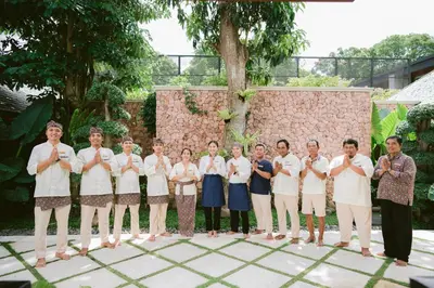 a group of people in white shirts posing for a picture at The Suaka Baliaga by Puri Asia in Seminyak