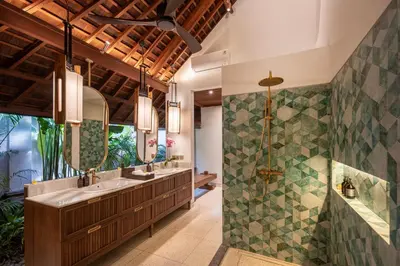 a bathroom with two sinks and a shower at The Suaka Baliaga by Puri Asia in Seminyak