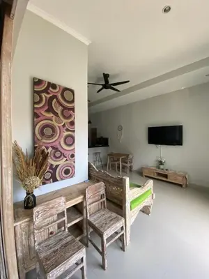 a living room with a table and chairs and a tv at Two spacious bedroom villa in Seminyak