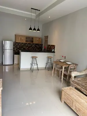 a kitchen with a table and a refrigerator at Two spacious bedroom villa in Seminyak