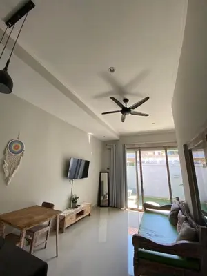 a living room with a ceiling fan and a couch at Two spacious bedroom villa in Seminyak