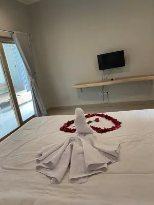 a white robe on a bed with flowers on it at Two spacious bedroom villa in Seminyak
