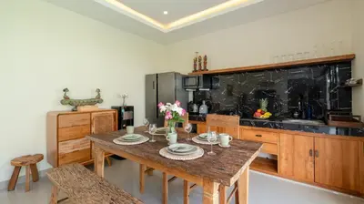 a kitchen with a wooden table and a counter top at Villa Lange 3 by Villa Finder in Seminyak