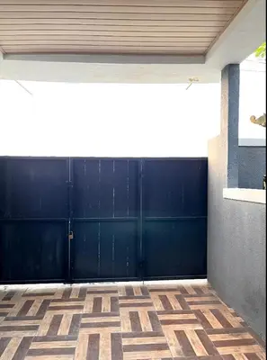 a garage with a blue garage door and a tile floor at Villa Teras Asri Seminyak in Denpasar