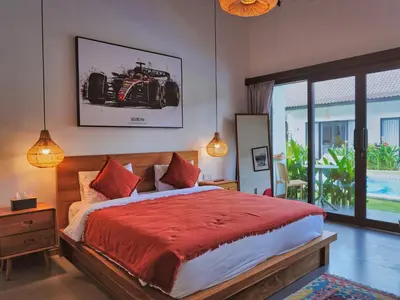 a bedroom with a large bed with a red blanket at Mistral Studio Umalas in Canggu