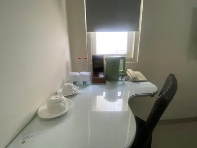 a white desk with two chairs and a telephone at AI Hotel Kuta - 15 Second to the Beach and 1 Minute to Airport by Micky Studio in Ngurah Rai International Airport