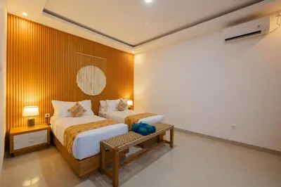 a hotel room with a bed and a table at Arvi Villa Pandawa Legian in Legian
