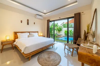 a bedroom with a bed and a pool at Alicia - Stylish 2BR Villa with Large Pool in Kerobokan
