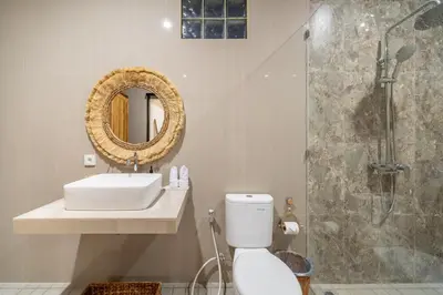 a bathroom with a sink and a toilet and a shower at Alicia - Stylish 2BR Villa with Large Pool in Kerobokan