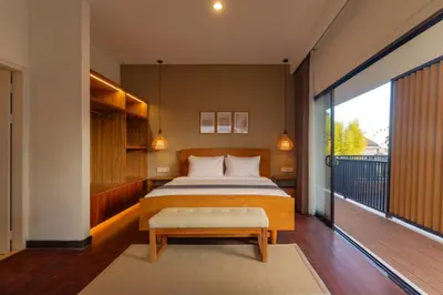 a bedroom with a large bed and a balcony at Villa Club Residence 8 by Maheswara in Canggu