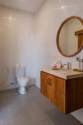 a bathroom with a toilet and a sink and a mirror at Villa Grace a 2BR Retreat with private pool in Seminyak