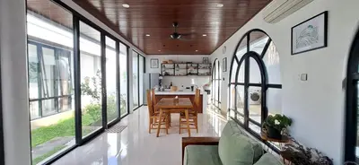 a living room with a table and some windows at Modern Tropical 2 Bedroom Villa Ocean Nest in Canggu