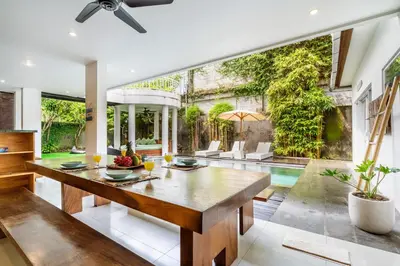 a dining room with a table and a pool at Beautiful villas - Right by the beach - Seminyak in Badung