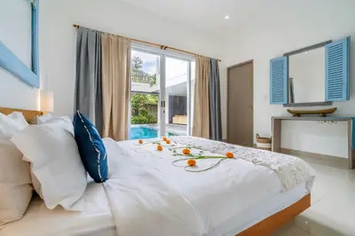 a white bed with fruit on it in a bedroom at Beautiful villas - Right by the beach - Seminyak in Badung