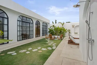 a backyard with a lawn with rocks on it at All-White Villa with Pool, Sauna, Firepit & Office in Jimbaran